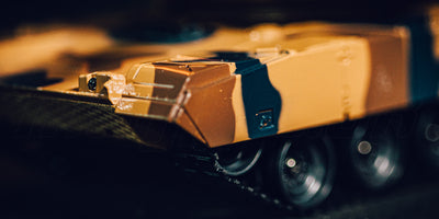 Grøn Battle Tank Metal Limited Edition fjernstyret kampvogn kører gennem mudret terræn i naturen.