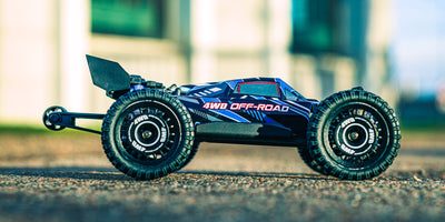 Blå MJX HyperGo Buggy 3S fjernstyret bil i fuld fart på græsset med hvirvlende støv.
