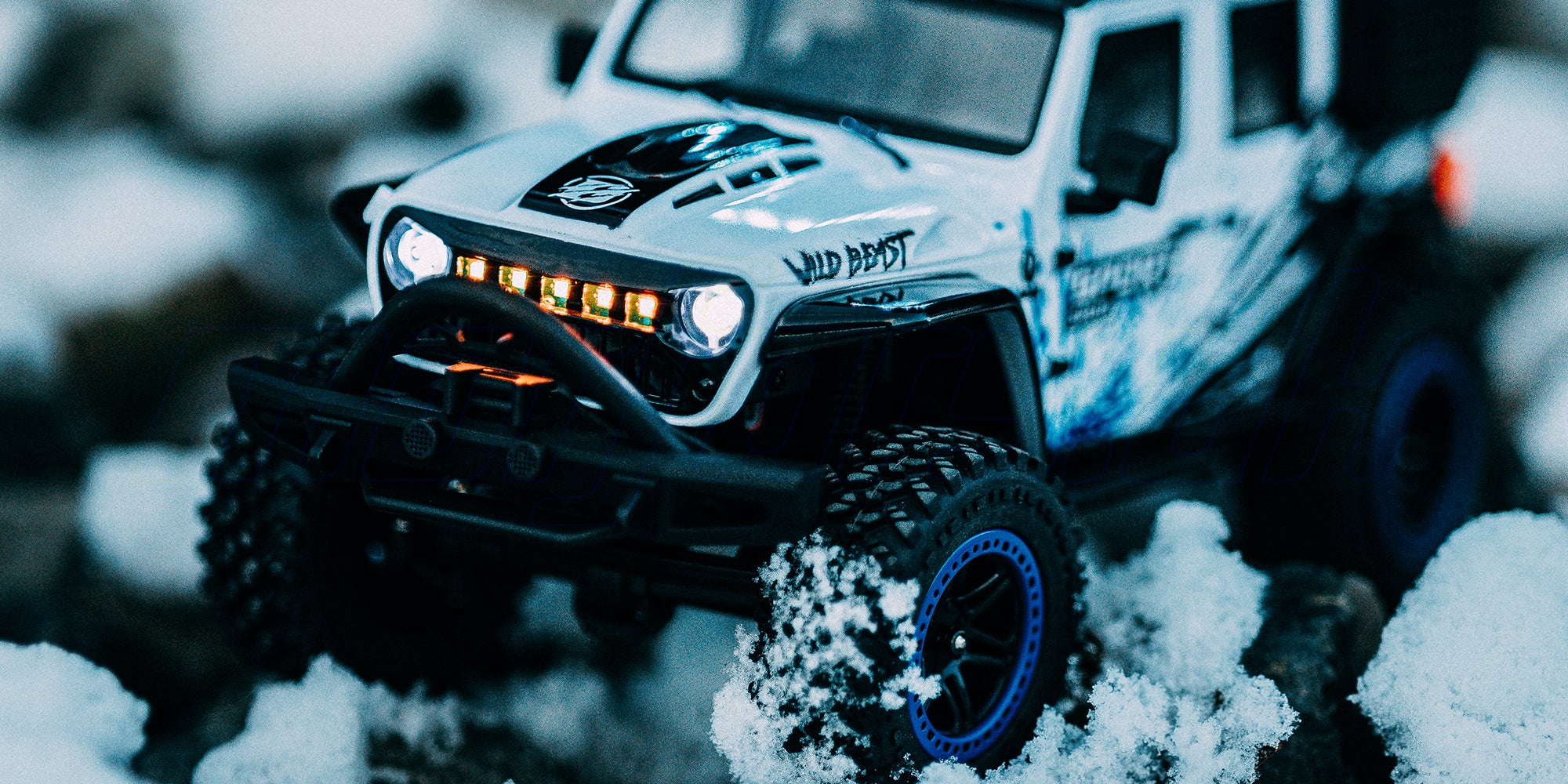 Wild Beast Mini Crawler fjernstyret bil forcerer grå sten i et realistisk terræn.