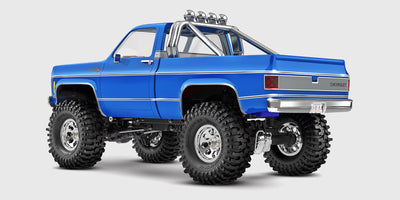 Traxxas TRX-4M Chevrolet K10 i rød set skråt forfra med detaljeret kromgrill og klassiske offroad-hjul.