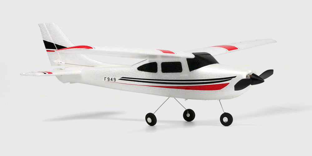 Hvidt fjernstyret Cessna 182 fly med blå detaljer klar til start på græsset.